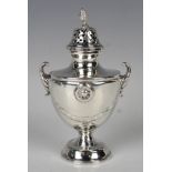 A George V Irish silver sugar caster of urn form with pierced domed cover and pine cone finial above