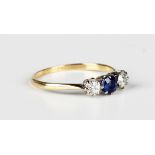 A gold, platinum, sapphire and diamond three stone ring, claw set with the circular cut sapphire