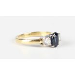 An 18ct gold ring, claw set with an oval cut sapphire between two circular cut diamonds, London