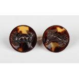 A pair of tortoiseshell earrings, each of dished circular form, mounted with dog head motifs, with