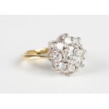 A gold and diamond cluster ring in a flowerhead shaped design, claw set with the principal