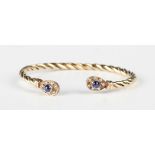 A 9ct gold, cabochon sapphire and colourless gem set bangle in a ropetwist design with pear shaped