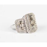 A 9ct white gold and diamond ring in a large triple panel shaped design, mounted with baguette and