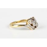 A gold, platinum, diamond and colourless gem set three stone ring in a twistover design, detailed '