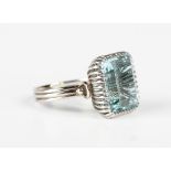 A white gold and aquamarine single stone ring, claw set with the large cut cornered rectangular step