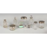 A group of cut glass dressing table bottles and jars with silver lids and collars, a .935 silver and