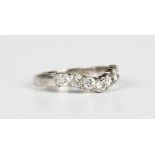 An 18ct white gold and diamond seven stone ring in a wishbone shaped design, claw set with