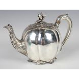 A William IV silver melon teapot, the leaf shaped hinged lid with flower bud finial flanked by a