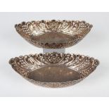 A pair of late Victorian silver boat shaped bowls, each with pierced lattice and embossed scroll