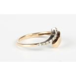 A 9ct two colour gold and diamond ring in an abstract twistover design, mounted with a row of
