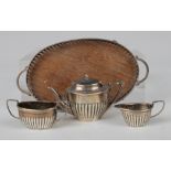 An Edwardian silver toy four-piece tea set of oval half-reeded form, comprising teapot, two-