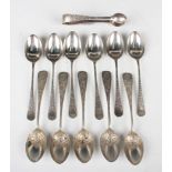 A set of six Edwardian silver teaspoons with engraved handles and a pair of matching sugar tongs,