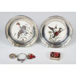 A pair of American sterling mounted porcelain circular pin dishes, each centre decorated with a