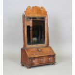 A Queen Anne walnut dressing table mirror, the base fitted with a hinged lid enclosing a writing