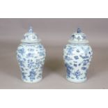 A pair of modern Chinese porcelain blue and white vases and covers, each decorated with vases of