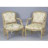 A pair of early/mid-20th century French painted showframe fauteuil armchairs, upholstered in woven