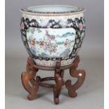 A 20th century Chinese porcelain jardinière on a shaped hardwood stand, the bowl decorated with