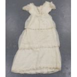 A group of mainly late 19th and early 20th century clothing, including a silk dress with applied
