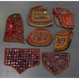 A group of five Indian Kutch finely embroidered hats, two with mirror work panels, together with two