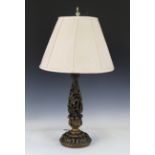 An early 20th century American gilt metal table lamp, ornately cast with exotic birds and stylized