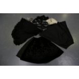 A selection of Victorian clothing, including a black velvet and silk shoulder cape, a similar