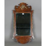 An early 20th century George III style walnut and parcel gilt fretwork wall mirror with carved