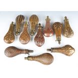 A collection of various 19th century copper powder flasks, all with embellished decoration to the