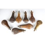 A group of seven various 19th century copper and brass powder flasks, all embossed with hunting