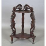 A 20th century Burmese hardwood two-tier corner shelf, the two supports finely carved with beasts