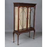 An early 20th century mahogany glazed display cabinet with blind fretwork frieze and carved cabriole
