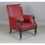An early Victorian ebonized armchair, upholstered in red leatherette, on reeded legs and castors,