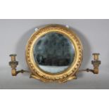 A Regency gilt wood and gesso framed convex girandole wall mirror fitted with two later candle