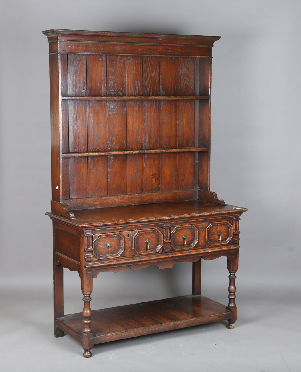 A 20th century William and Mary style oak dresser, the two drawers with applied geometric mouldings,