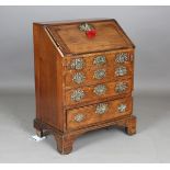 A small George III oak bureau, the fall flap above four drawers with elaborate brass handle