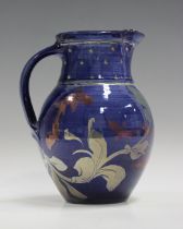 A Jonathan Chiswell Jones studio pottery lustreware jug, decorated with fish amongst weeds against a