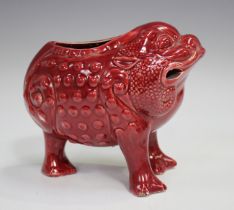 A Wardle ruby glazed pottery spoon warmer in the form of a three-legged grotesque toad, circa