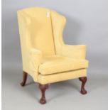 A mid-20th century George III style wing back armchair, raised on carved cabriole legs, height