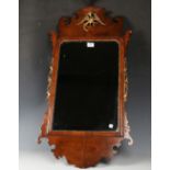 A George III style walnut and parcel gilt fretwork wall mirror with a carved and pierced phoenix