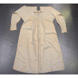 A quantity of early 20th century textiles, including a cream linen smock with foliate embroidery,