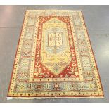 An Afghan rug, modern, the red field with a large reserve, within a blue star gul and leaf border,