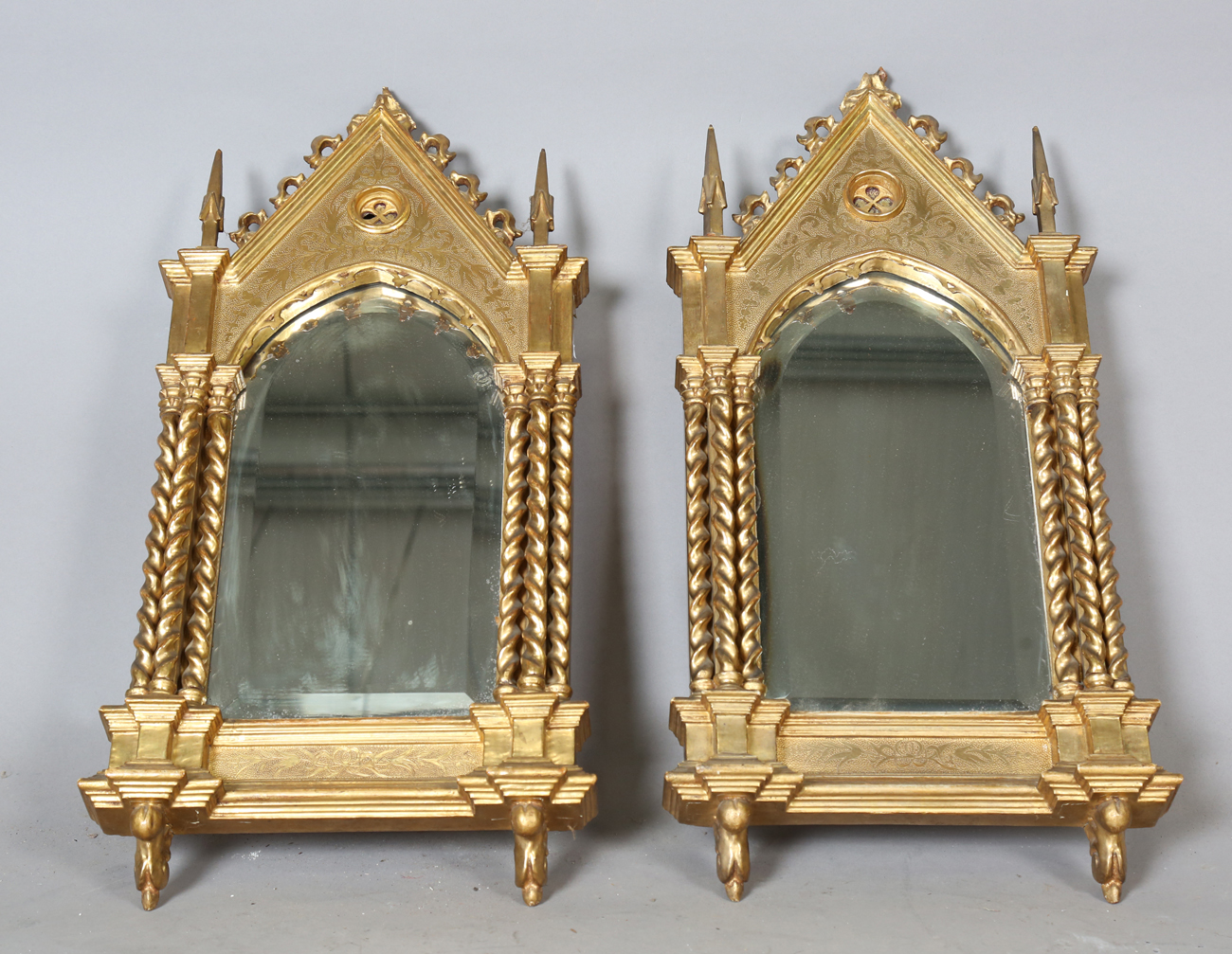 A pair of late 19th century Gothic Revival giltwood and gesso wall mirrors of arched architectural