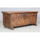 A 16th century Gothic oak coffer, the later lid above a carved tracery front, raised on later sledge