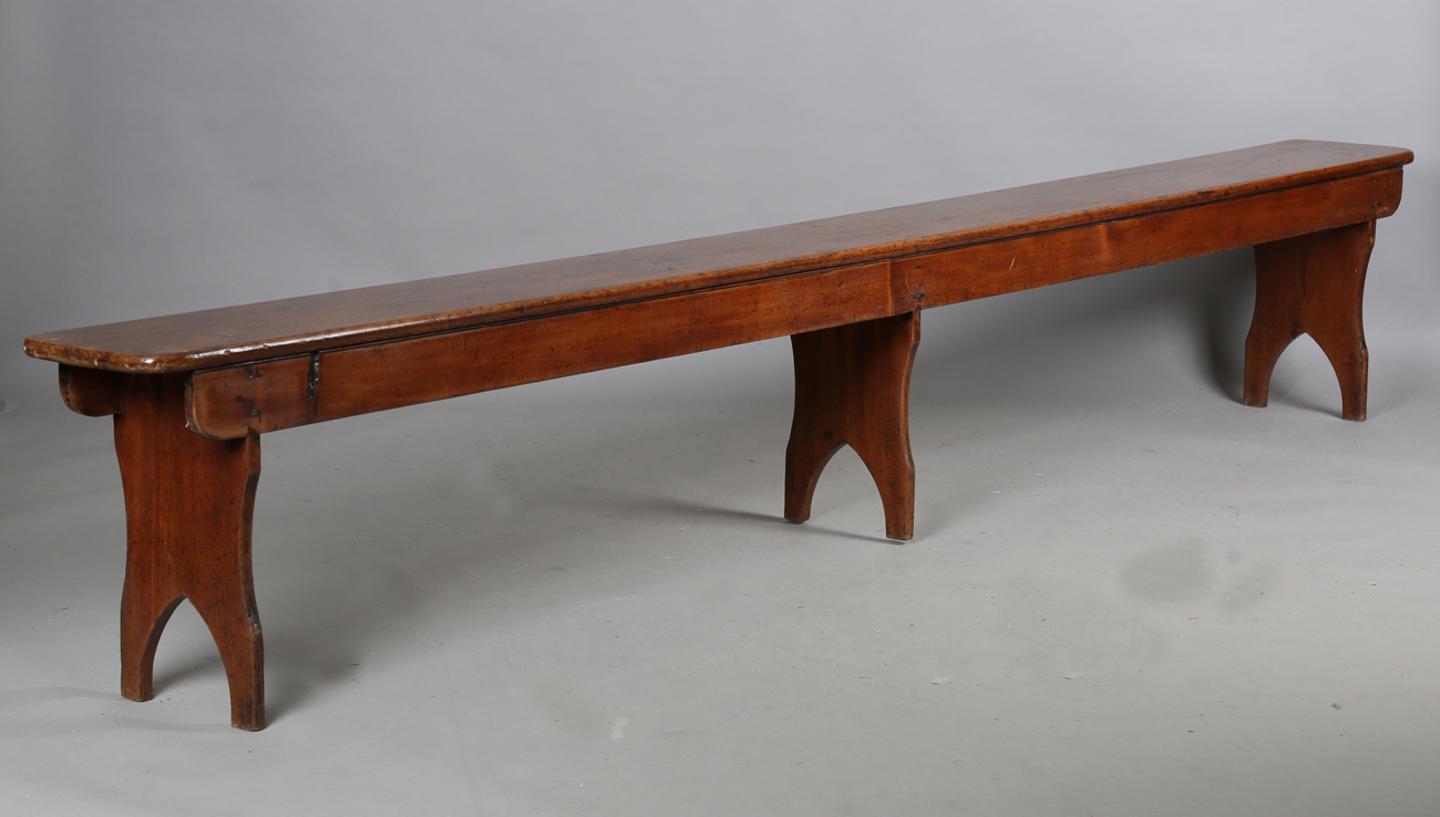 A pair of late 19th century stained pine benches, each raised on three shaped supports, height 47.