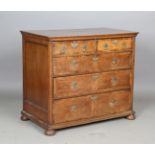 A George I provincial oak chest of drawers with fruitwood crossbanding, raised on bun feet, height