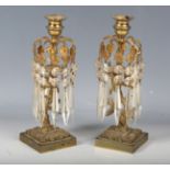 A pair of Regency gilt metal single-light table lustres, hung with cut glass drops, on a