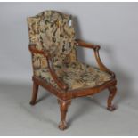 An early 20th century George III style walnut framed Gainsborough library armchair, raised on carved