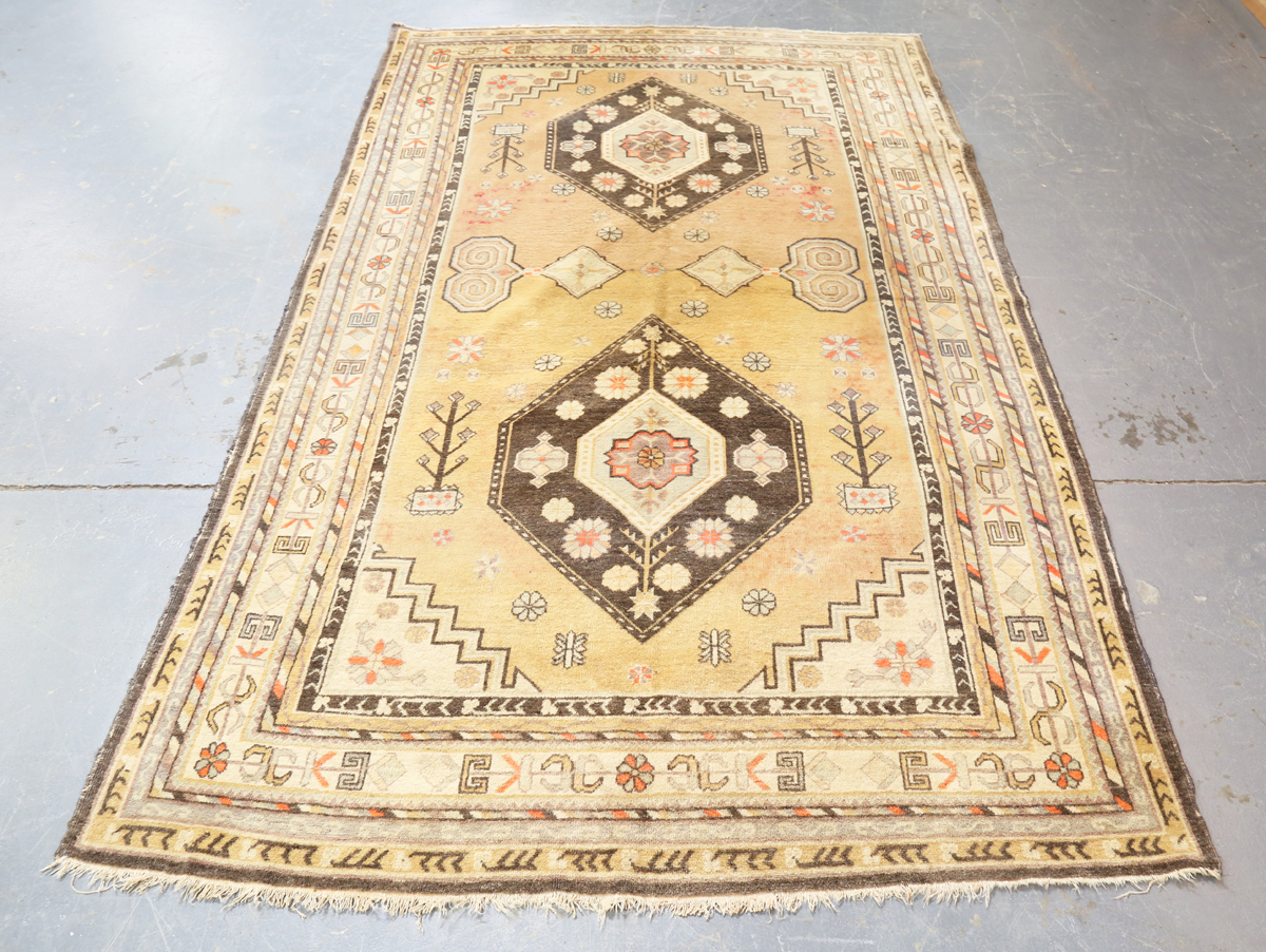 A South-west Persian rug, mid-20th century, the faded yellow field with two lozenge medallions,
