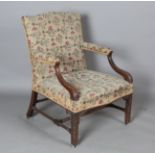 A George III mahogany Gainsborough armchair, upholstered in floral needlework, the armrests and