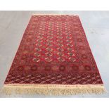 A Turkmenistan bokhara carpet, early/mid-20th century, the claret field with four rows of guls,