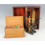 A late 19th century lacquered brass monocular field microscope, within a fitted mahogany box,